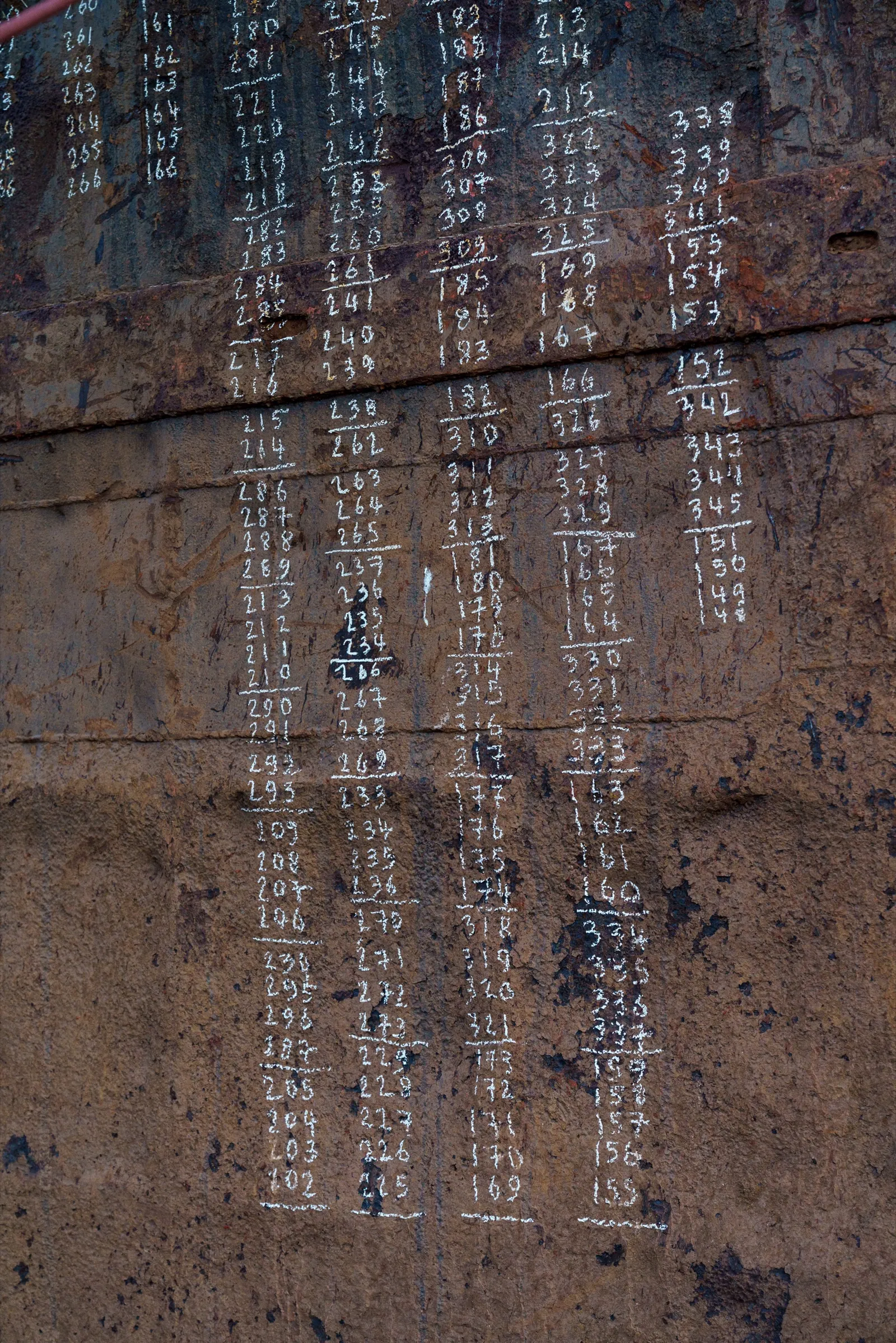 The Barge — chalk numeration on the rusted steel of the cargo hold, Old Goa, 2025